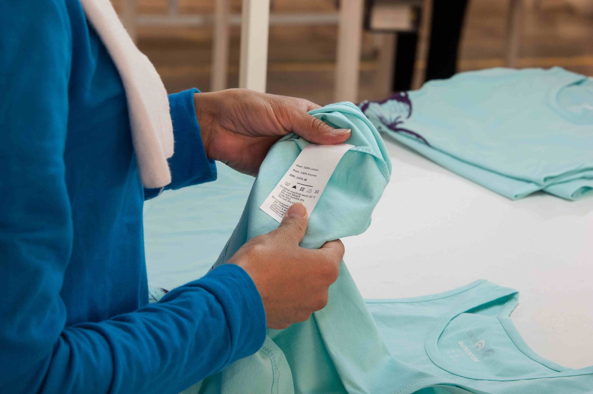 Checking the care label on a finished sample tee